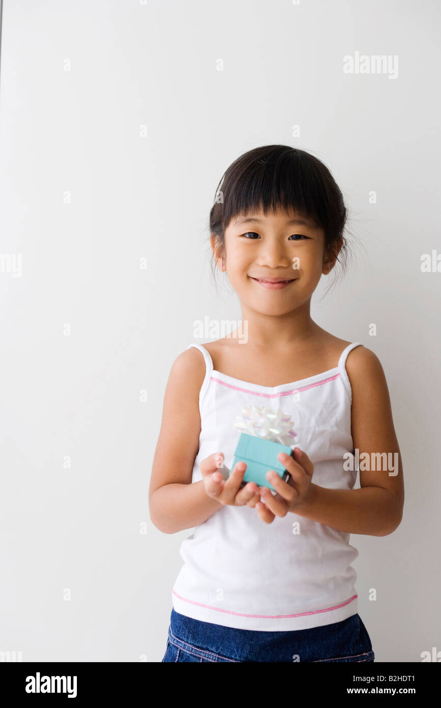 Portrait of a girl holding a gift and smiling Stock Photo - Alamy