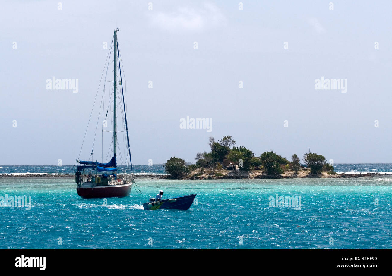 Yacht moored off Union Island, Grenadines, Caribbean with water taxi and small island. Stock Photo