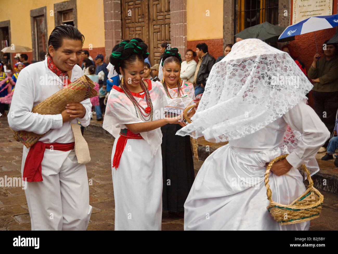 MEXICANS in PEASANT COSTUME WEDDING DRESS walk in the FESTIVAL DE SAN MIGUEL ARCHANGEL PARADE SAN MIGUEL DE ALLENDE MEXICO Stock Photo