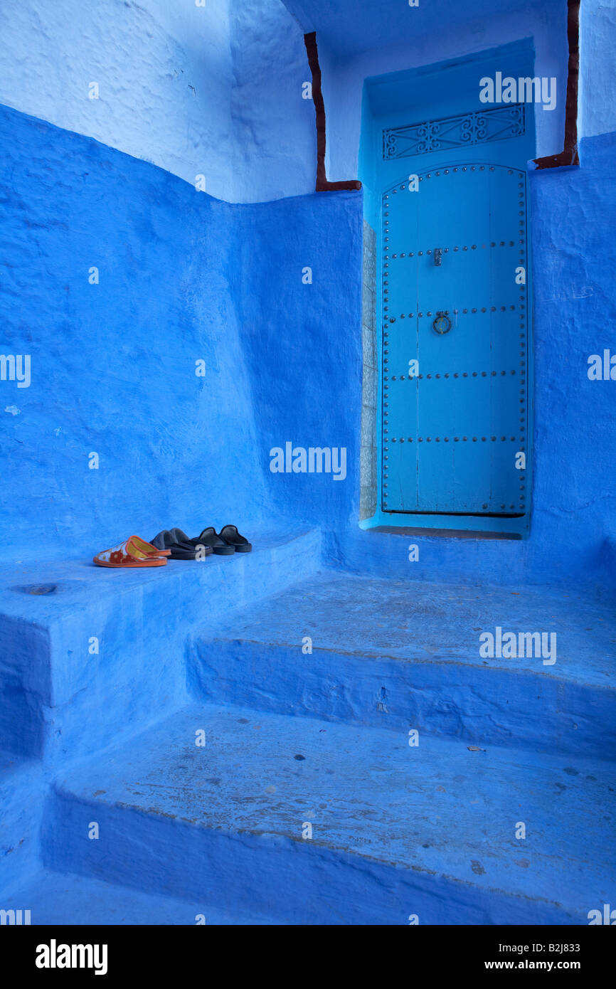 shoes left outside by a door in the blue walled town of Chefchaouen, Morocco Stock Photo