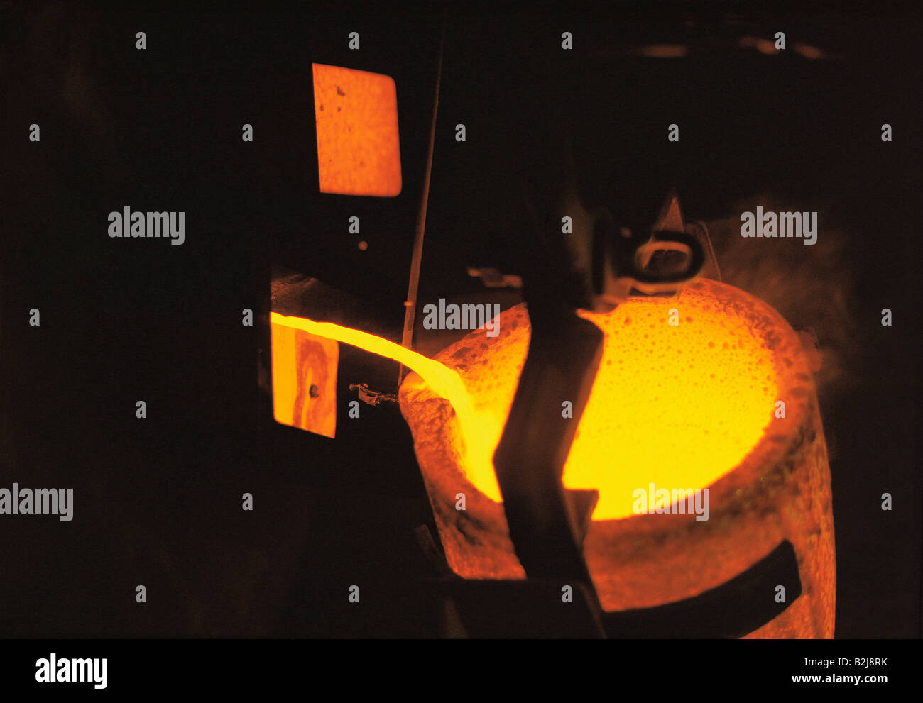 Overhead view of a furnace in detail. Molten gold metal pouring. Stock Photo