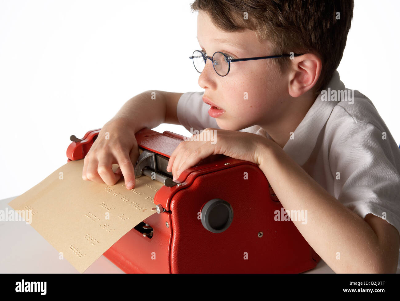 A visually impaired blind school boy using a braille machine brailler Stock Photo