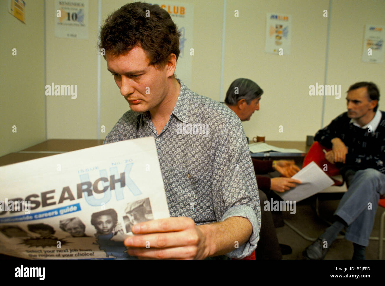 Man reading a jobsearch newspaper in an executive job club in Wiltshire, UK. Stock Photo