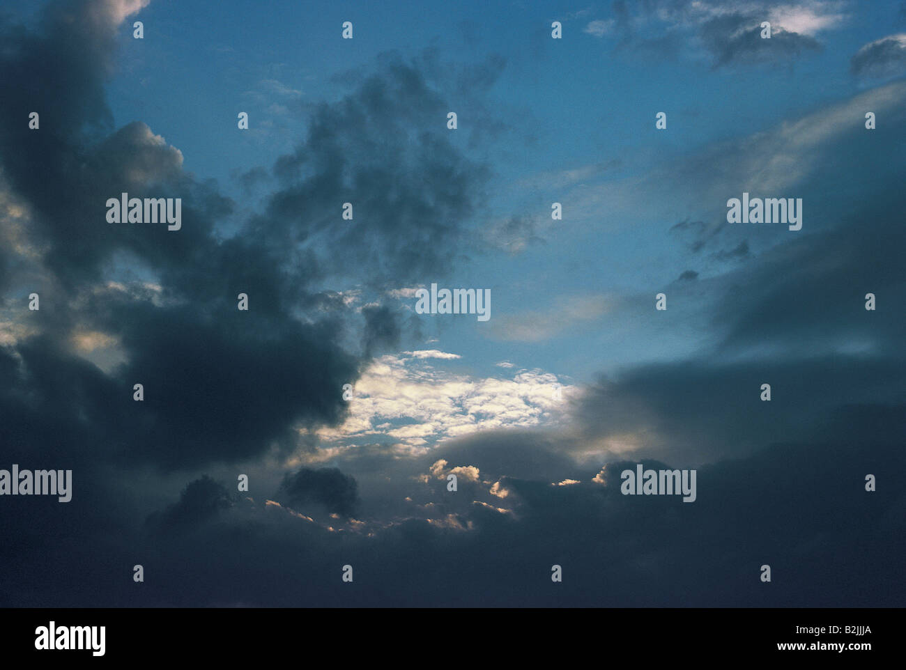 Heavy nimbostratus and altocumulus clouds gathering at dusk in a dark, forbidding sky. Stock Photo