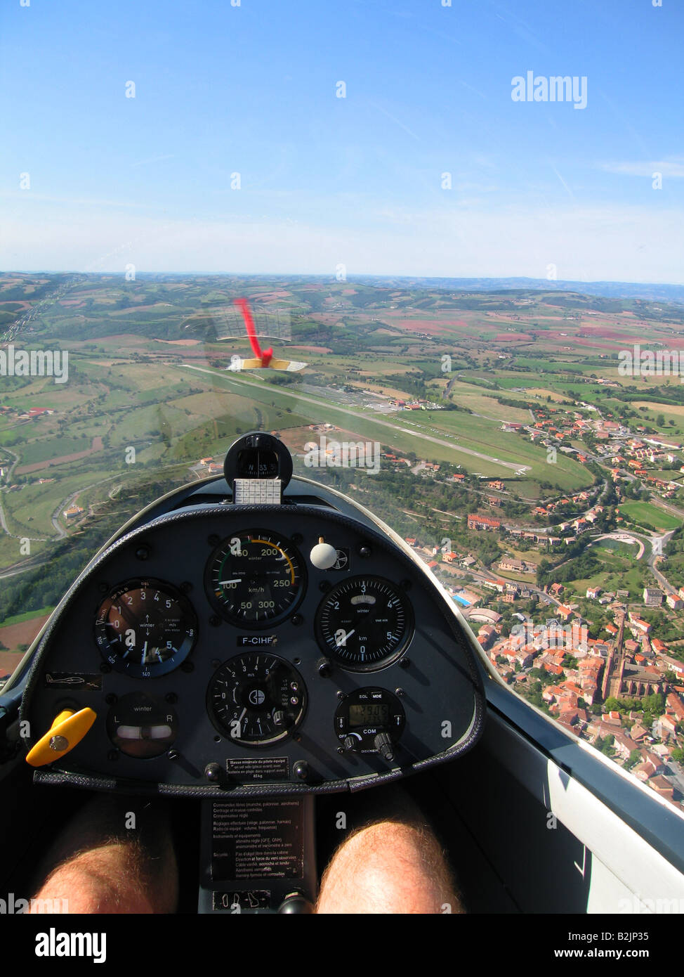 Pilot's eye view from a glider cockpit during flight near the airfield. Note the french rural landscape on a sunny day Stock Photo