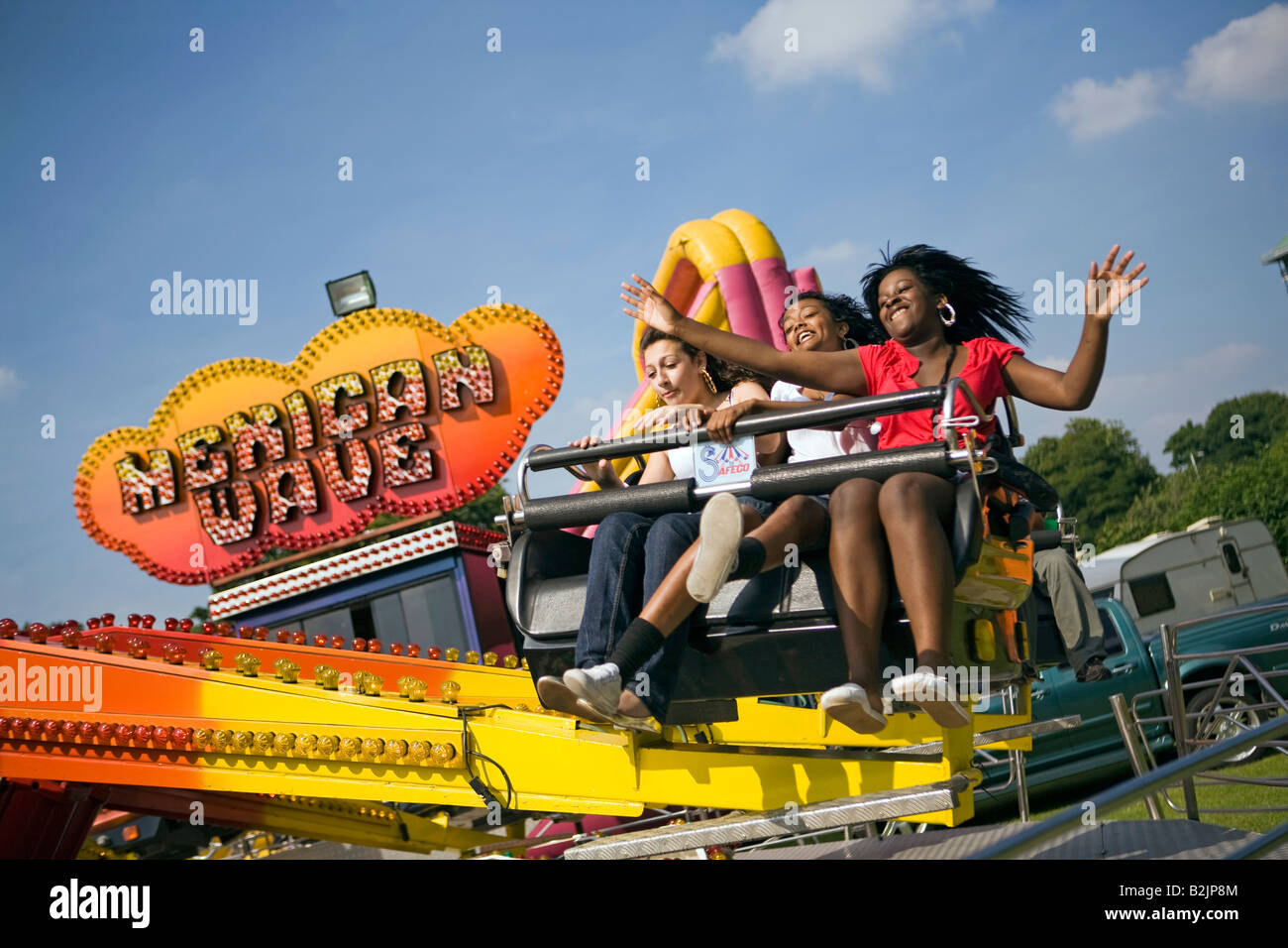 UK England Manchester Platt Fields Mega Mela young girls on Mexican wave rotating fairground ride Stock Photo