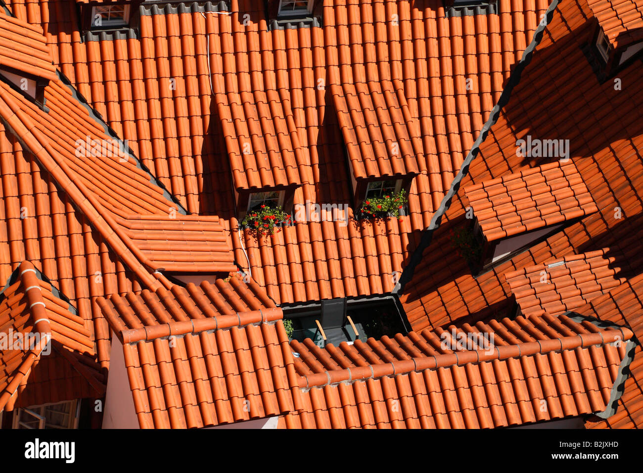 Red tile roof with attic windows decorated with geraniums located in the Lesser Quarter Square near St. Nicolas Cathedral Prague Stock Photo