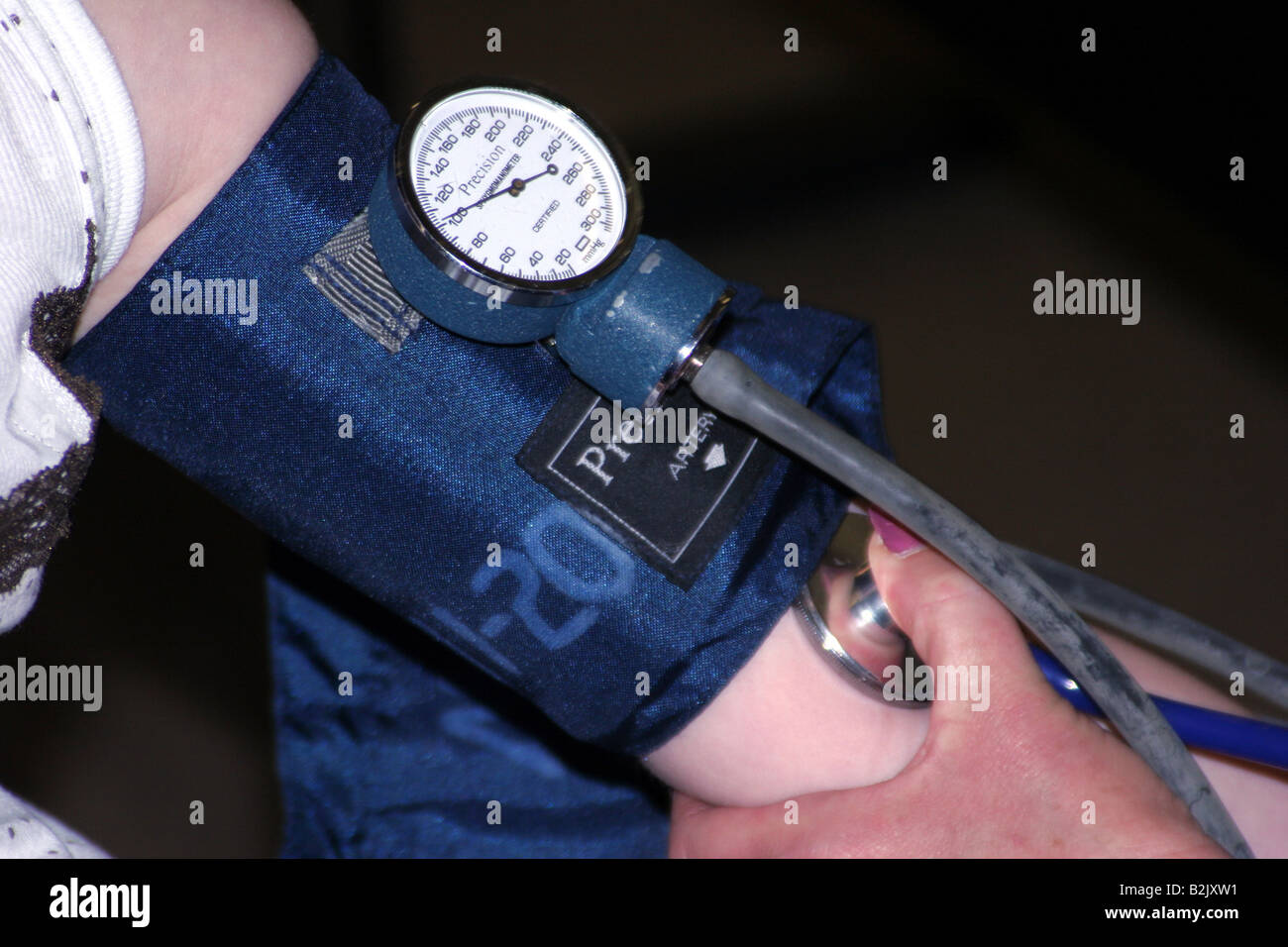 An EMT taking the blood pressure and listening to the heartbeat of a female patient Stock Photo