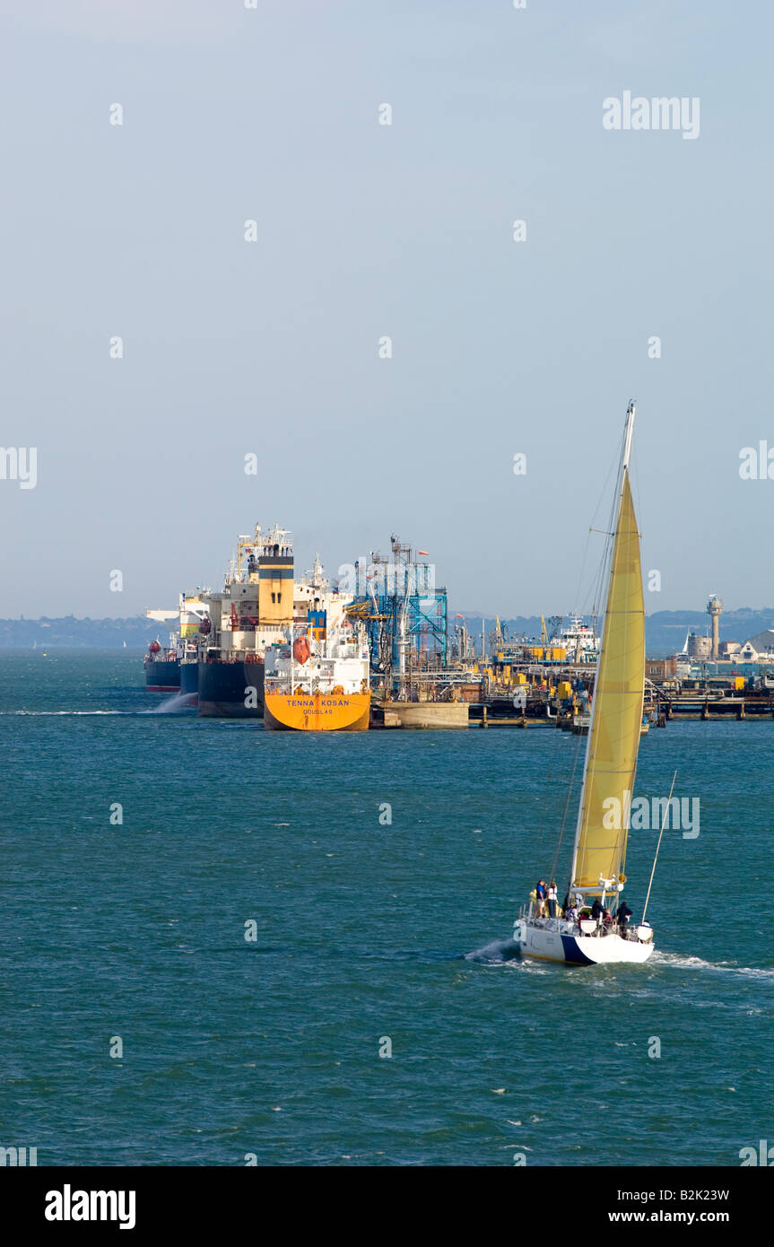 Yacht sailing by harbour terminal Southampton United Kingdom Stock