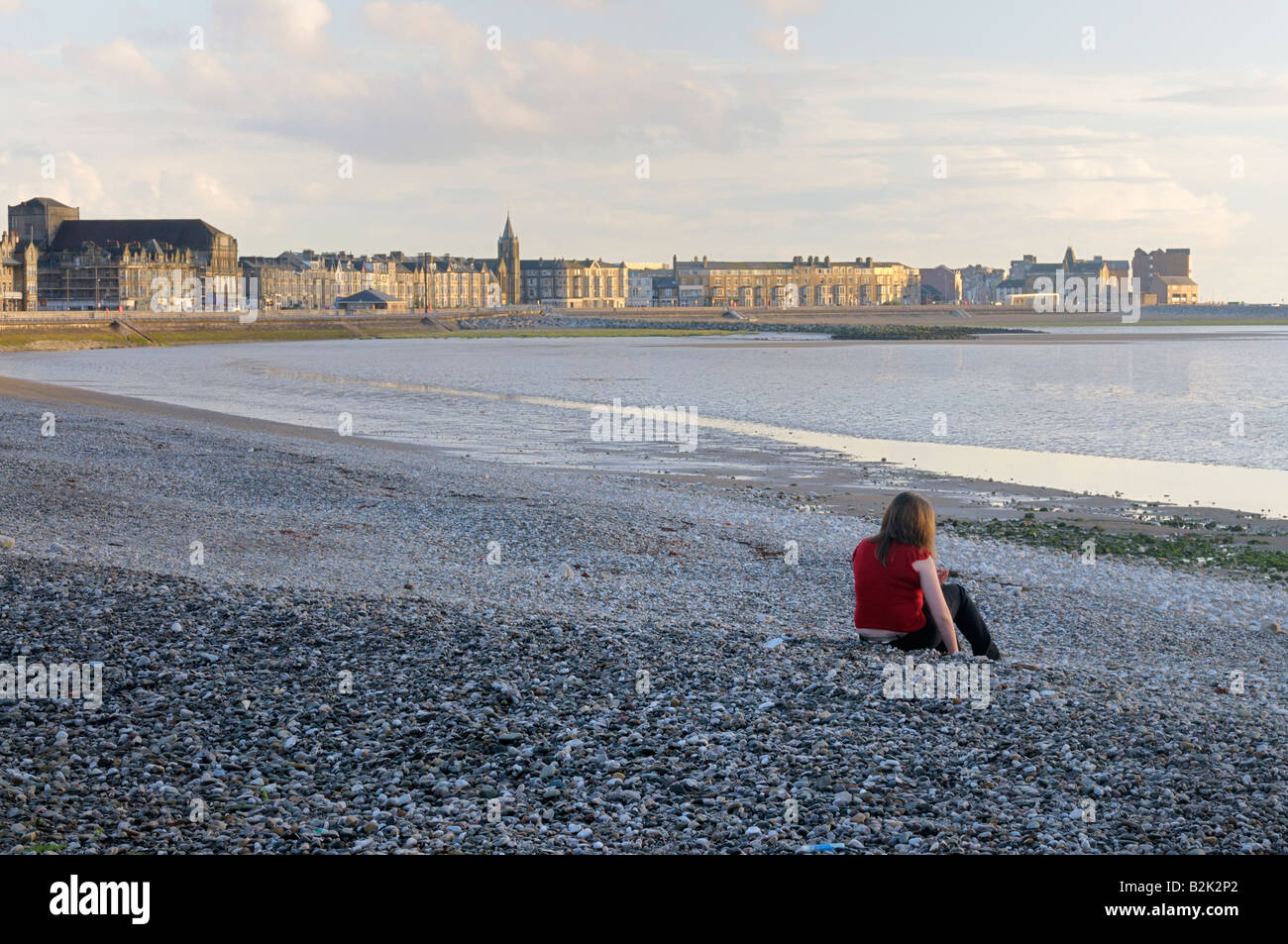 Young woman alone on Morecambe beach Stock Photo