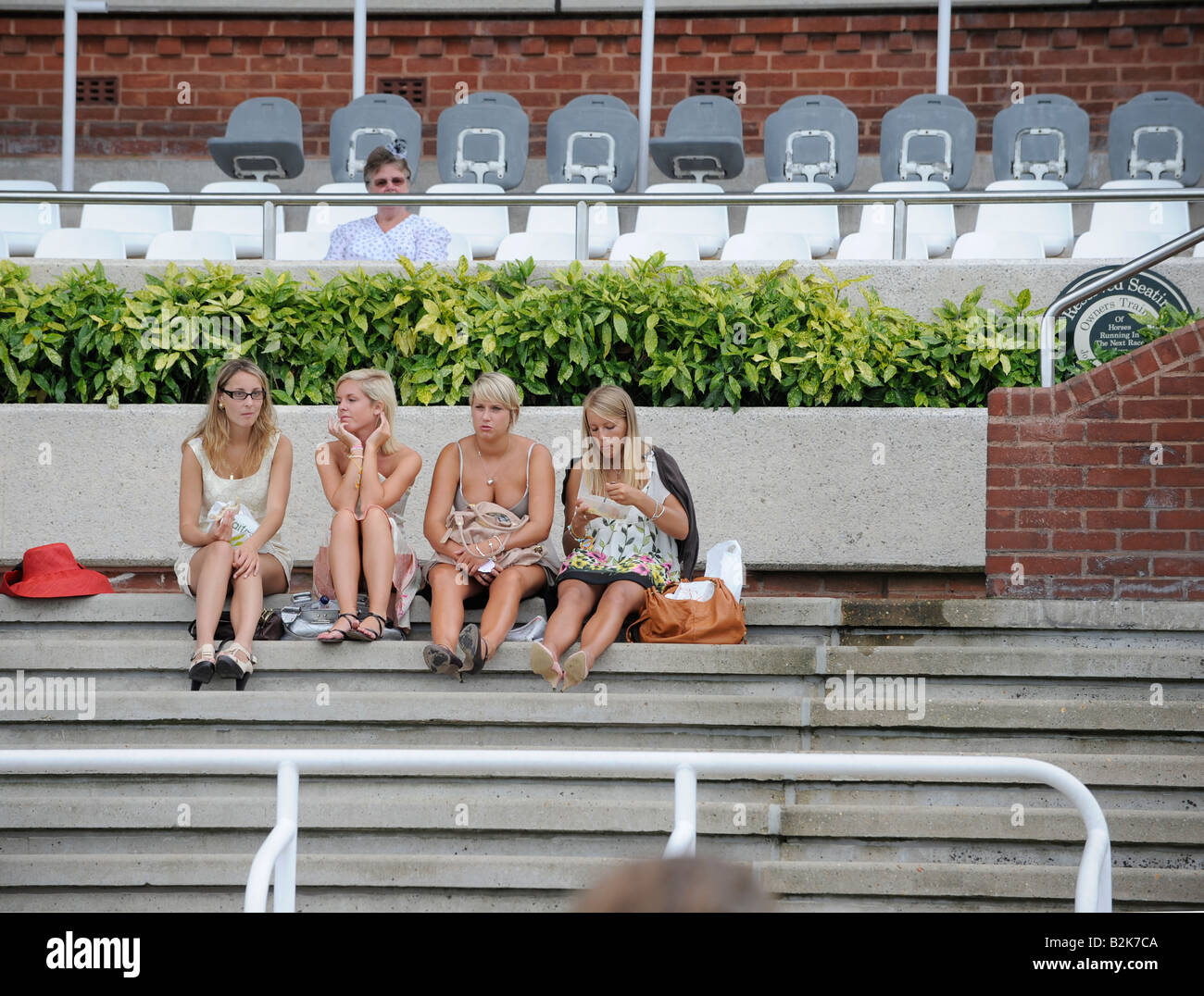 Glorious Goodwood: four young women taking a break from the festivities of Ladies' Day. Stock Photo