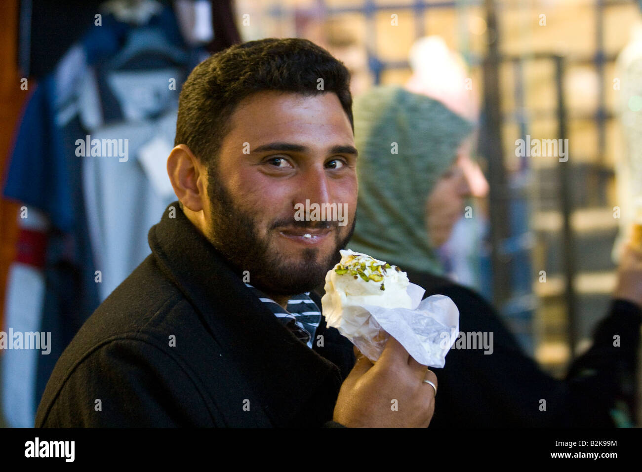 Man Eating Ice Cream from Bekdach Ice Cream Parlour in the Hamidiyya Souq in Damascus Syria Stock Photo