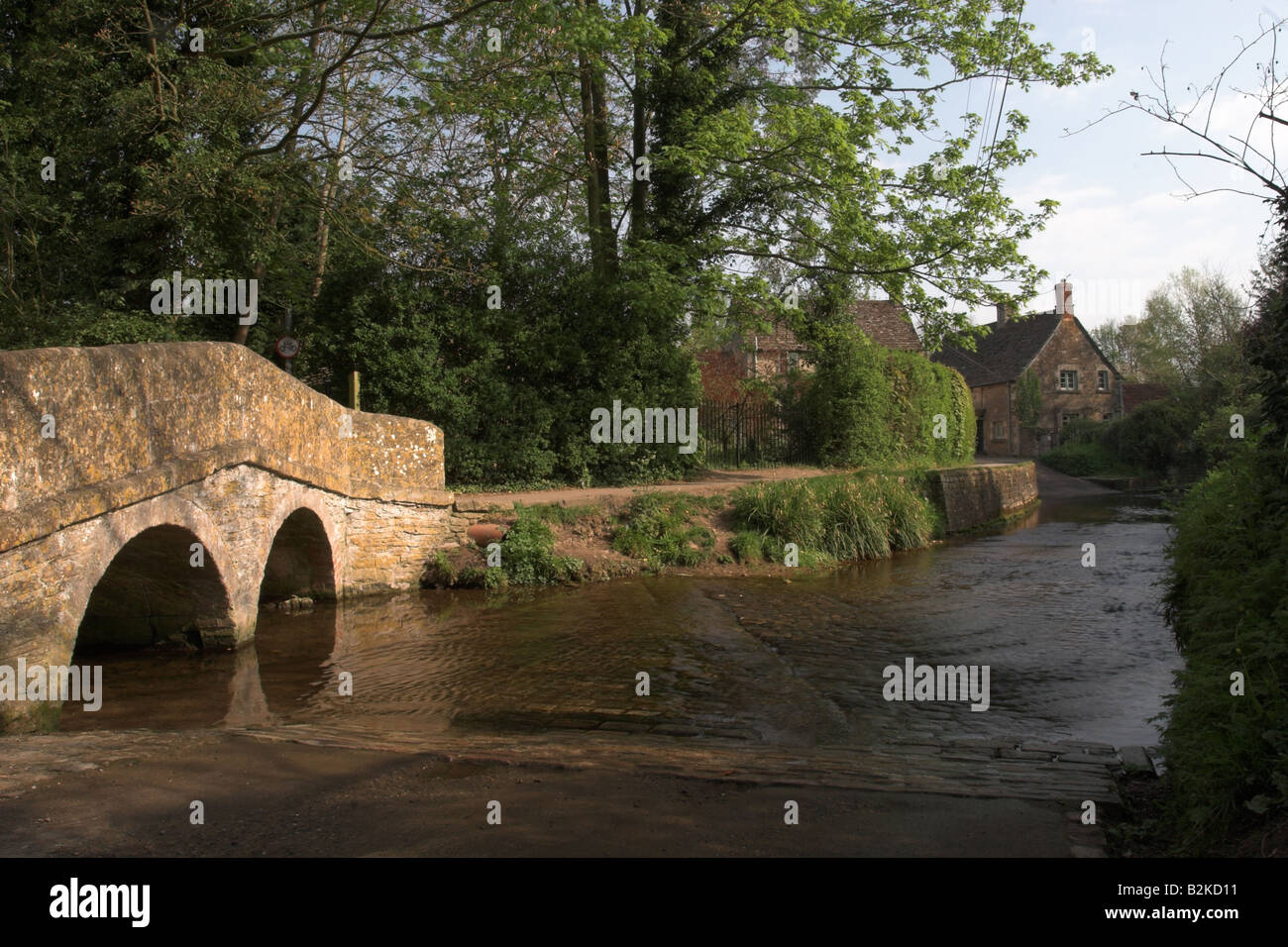 The packhorse bridge over Byde Brook ford in the picturesque village of Lacock, Wiltshire, England, UK Stock Photo