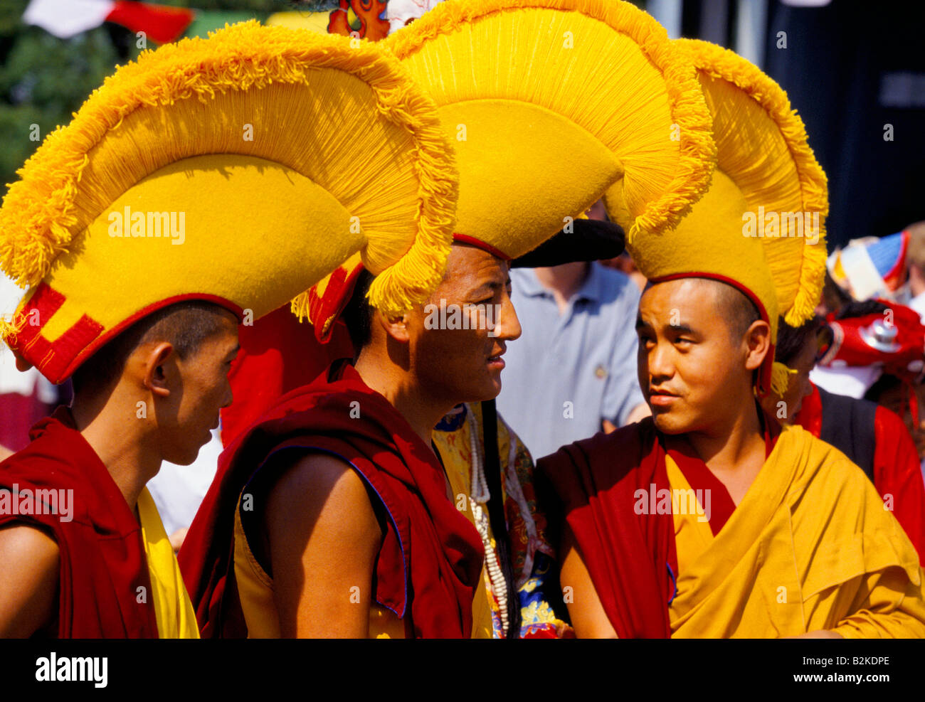 TIBETAN BUDDhIST MONKS WEARING TRADITIONAL MAROON ROBES FRINGED YELLOW HATS AT CONCERT FOR TIBET Stock Photo