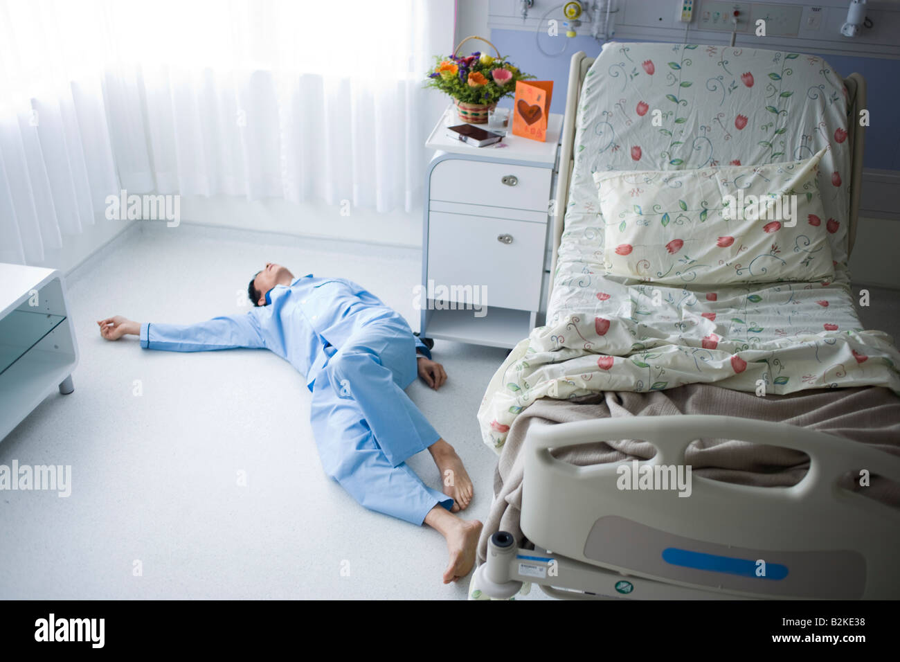 High angle view of a male patient lying unconscious on the floor Stock