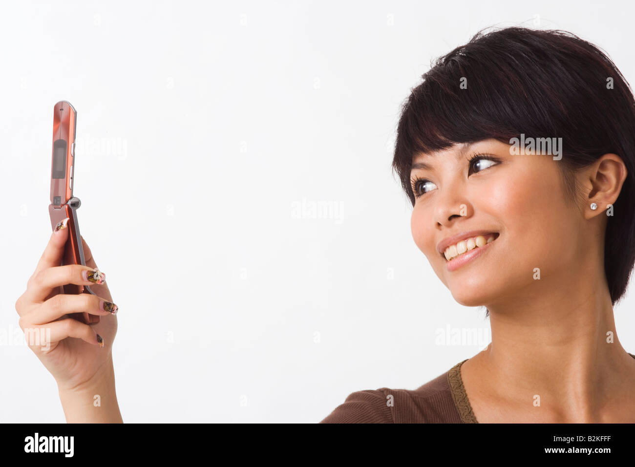 Close-up of a young woman text messaging and smiling Stock Photo - Alamy
