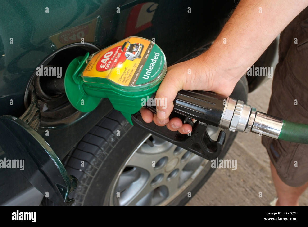 Filling car petrol tank with unleaded fuel at a Tesco filling station