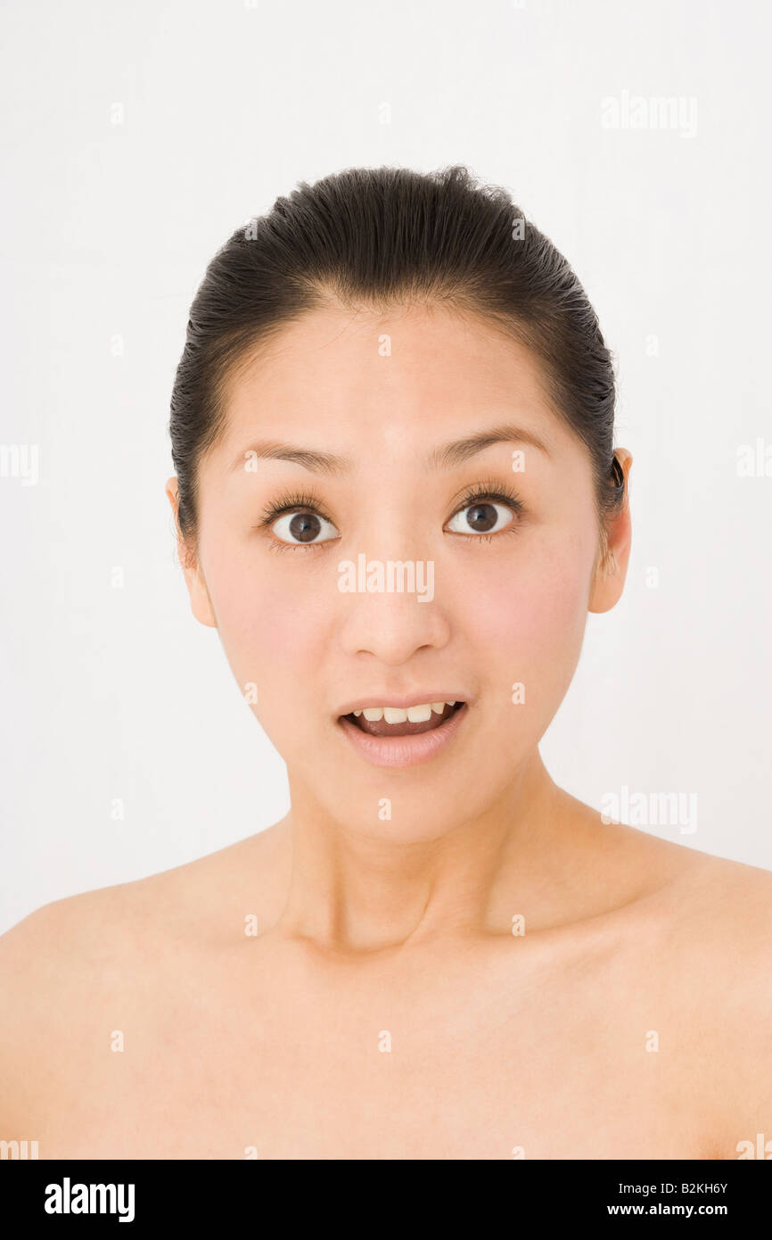 Portrait of a young woman looking surprised Stock Photo - Alamy
