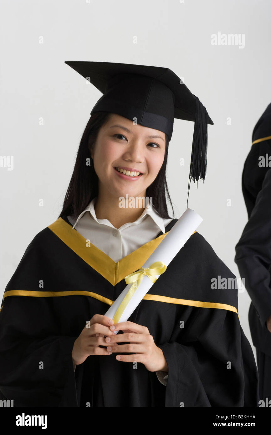 Portrait of a young female graduate holding a diploma and smiling Stock ...