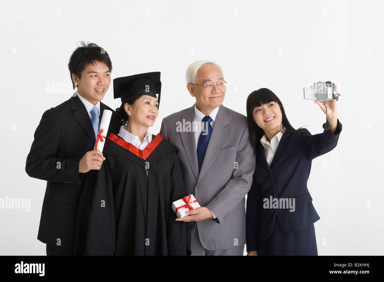 Family Using Filming Camera Young woman with her family filming themselves with a home video camera ...