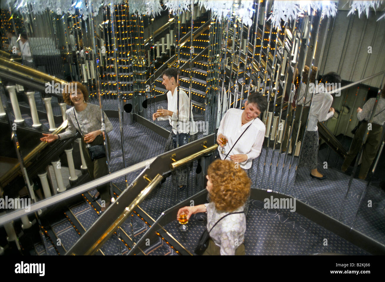 2 women walking down stairs with walls of mirrors at victoria s disco nightclub in glasgow 1990 Stock Photo
