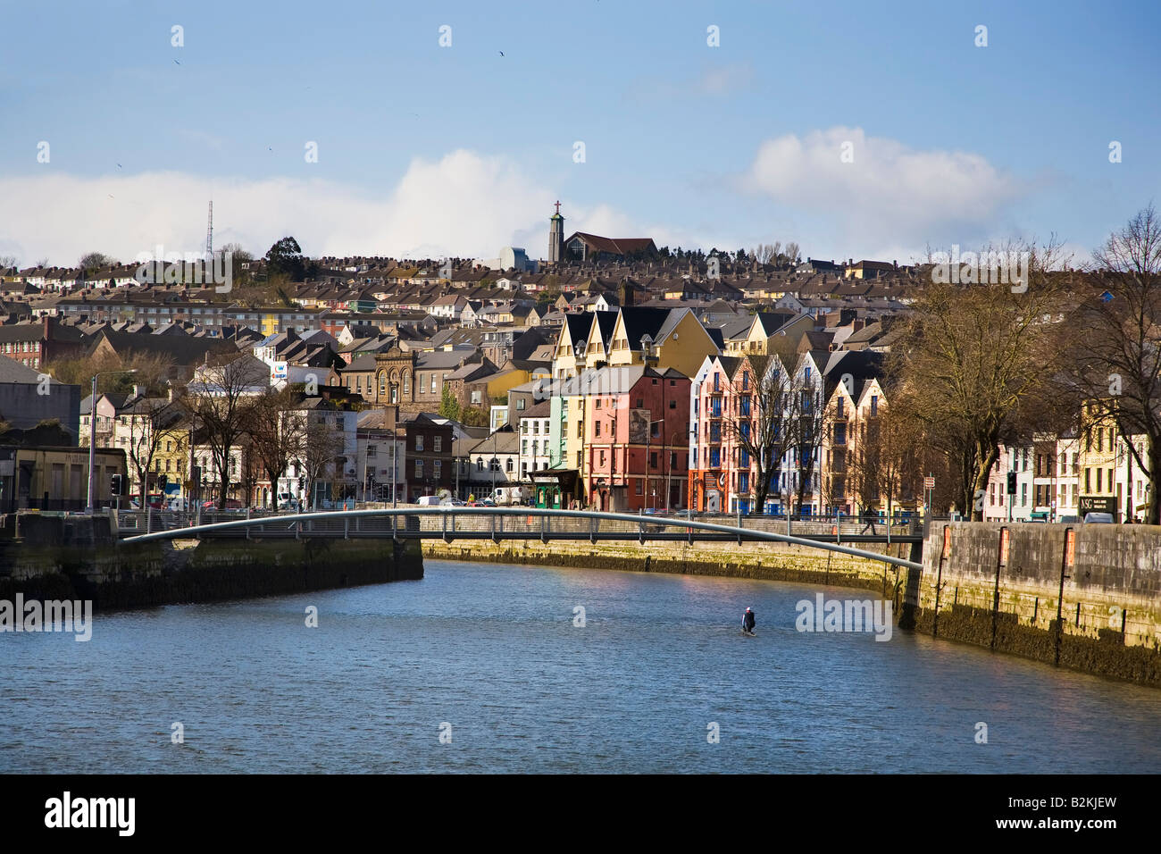 Man in a kneeling canoe making his way up the River Lee in the centre of  Cork City, Ireland Stock Photo