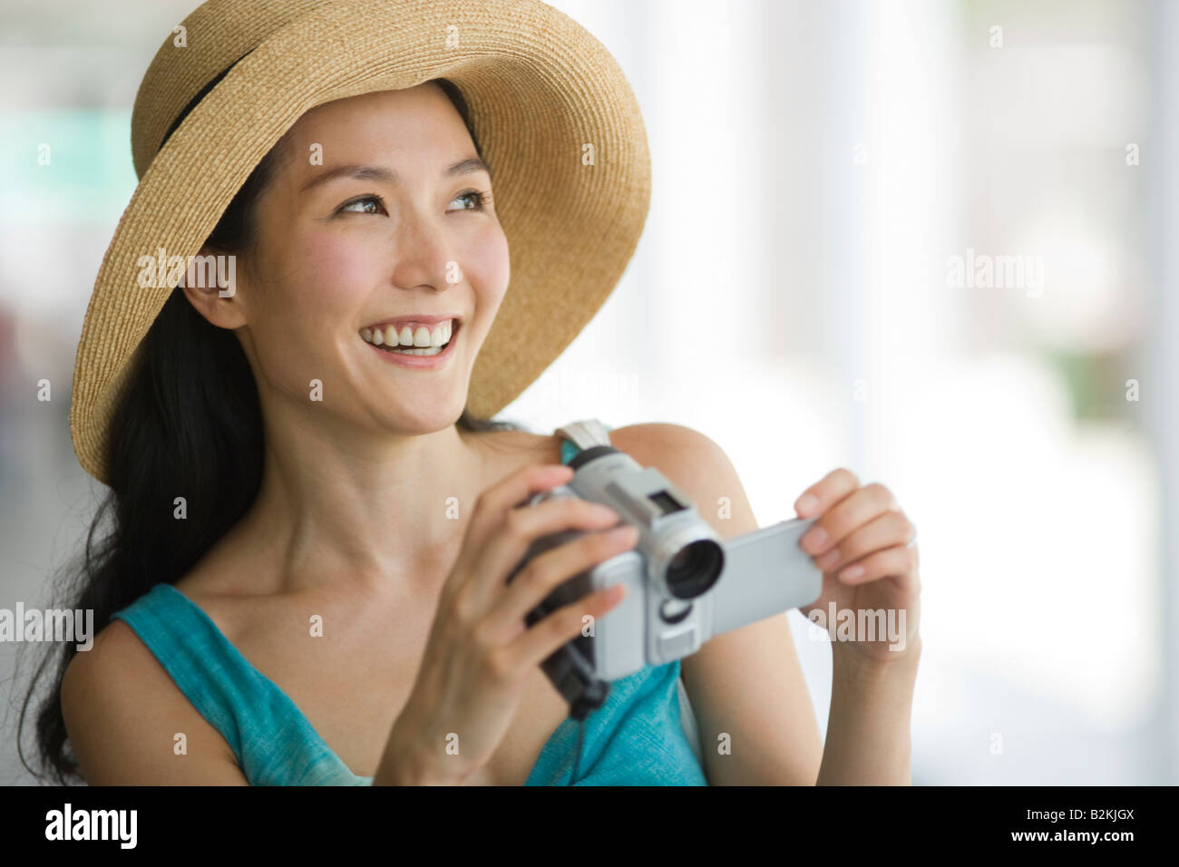 Close-up of a young woman holding a home video camera and smiling Stock ...