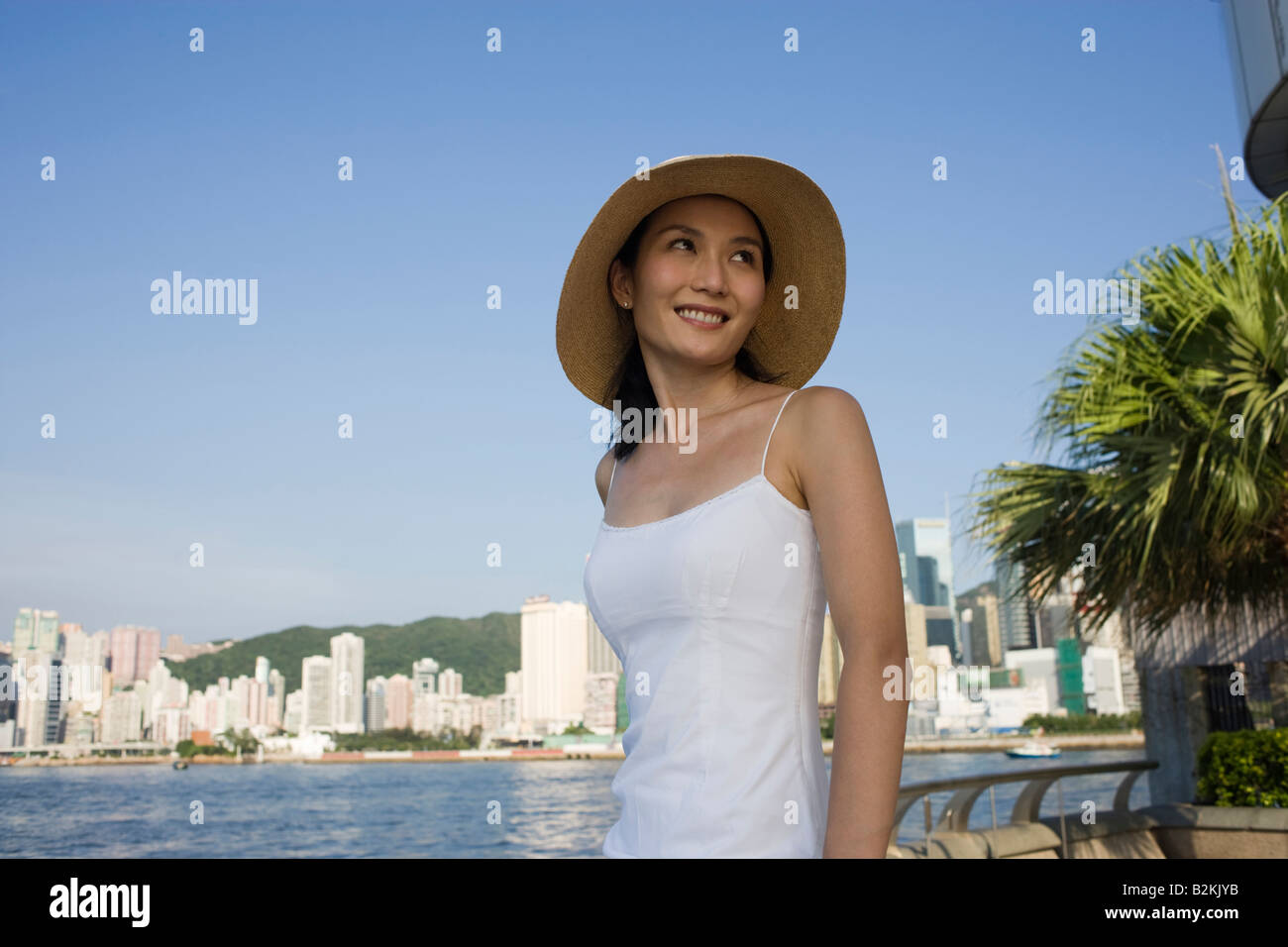 Young woman standing at the seaside and smiling Stock Photo - Alamy