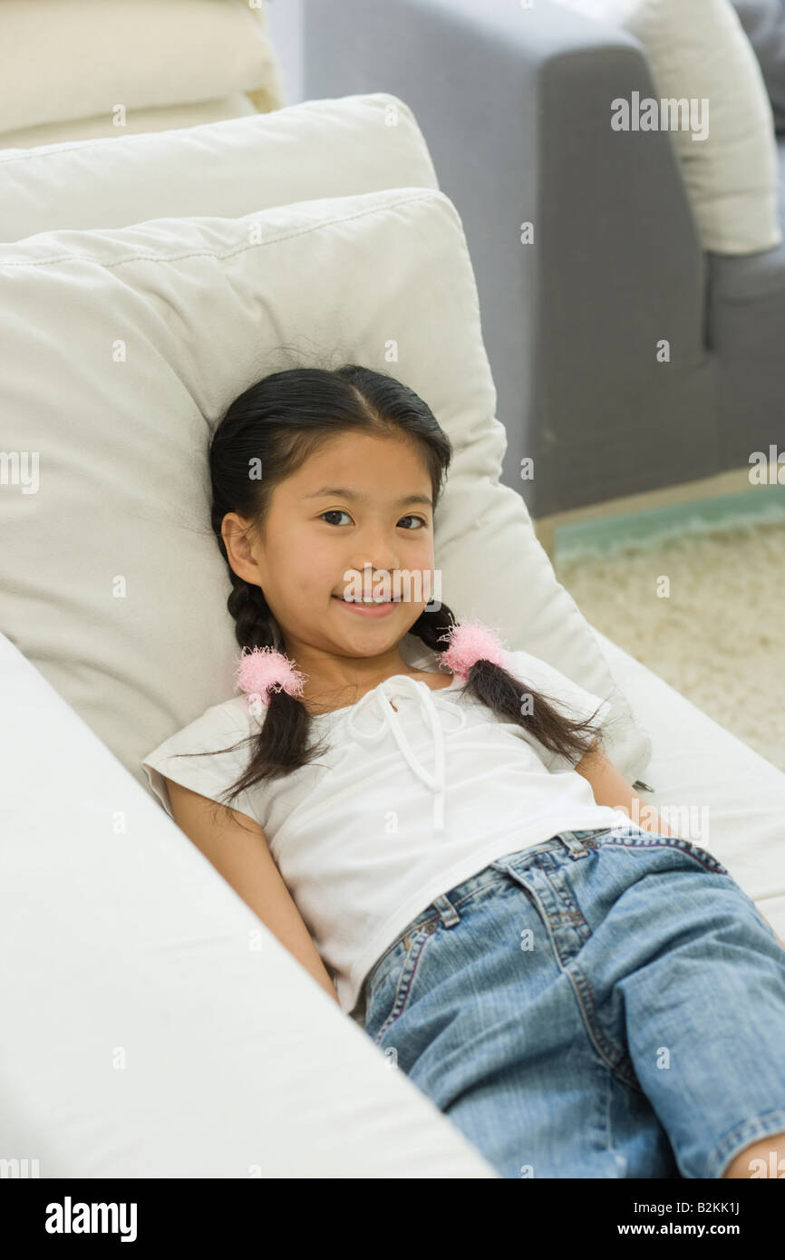 Portrait of a girl lying on a couch and smiling Stock Photo