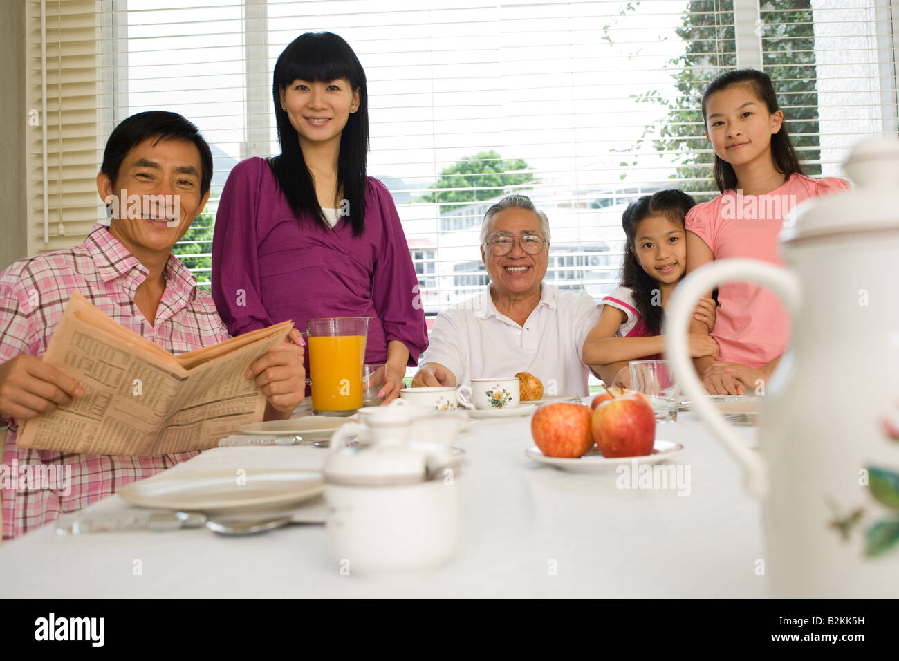 Portrait of a family smiling at a breakfast table Stock Photo - Alamy