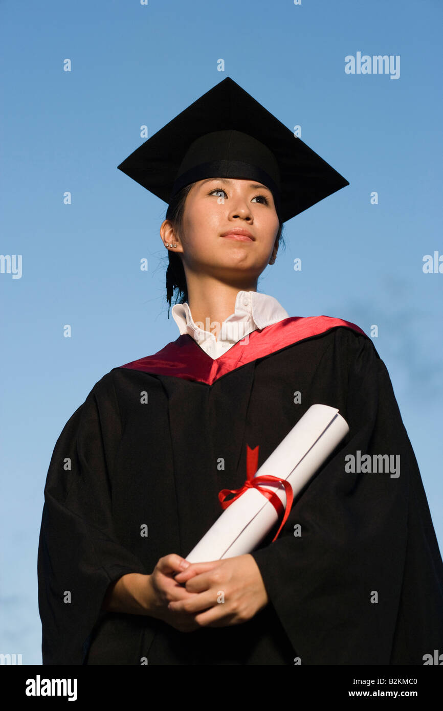 Low angle view of a young female graduate holding a diploma Stock Photo ...