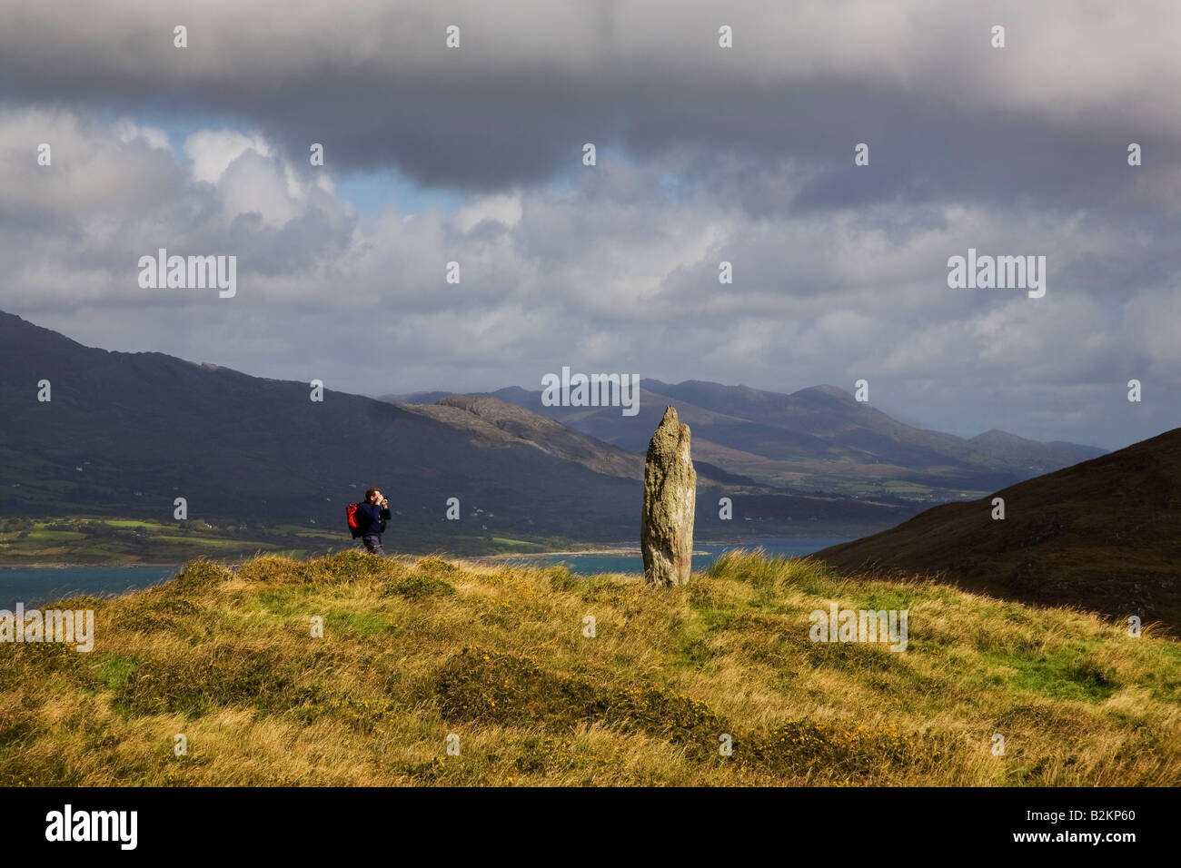 Photographer by Standing Stone, Bear Island, County Cork, Ireland Stock