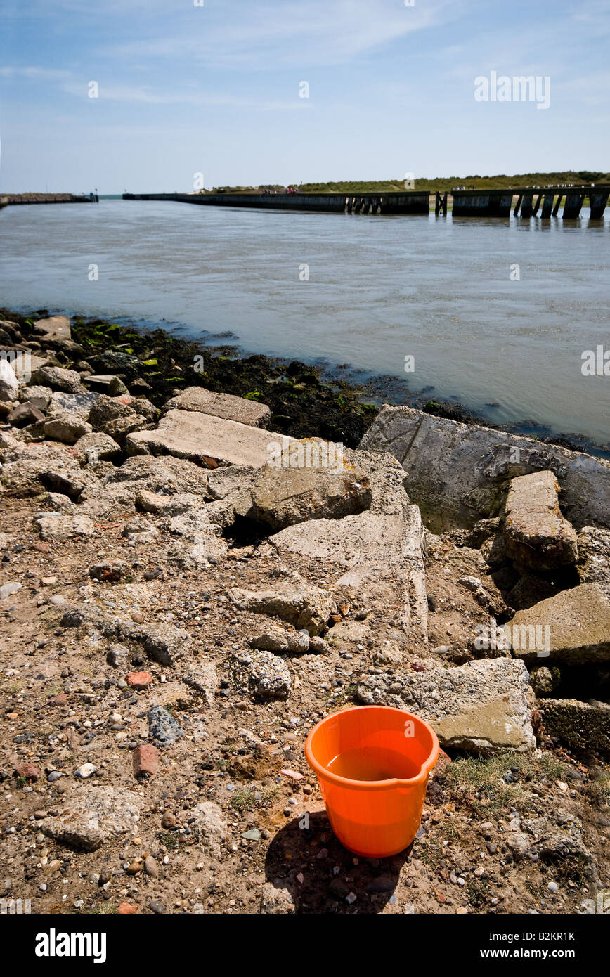 A plastic bucket on the banks of the River Blythe at Southwold in Suffolk. Stock Photo