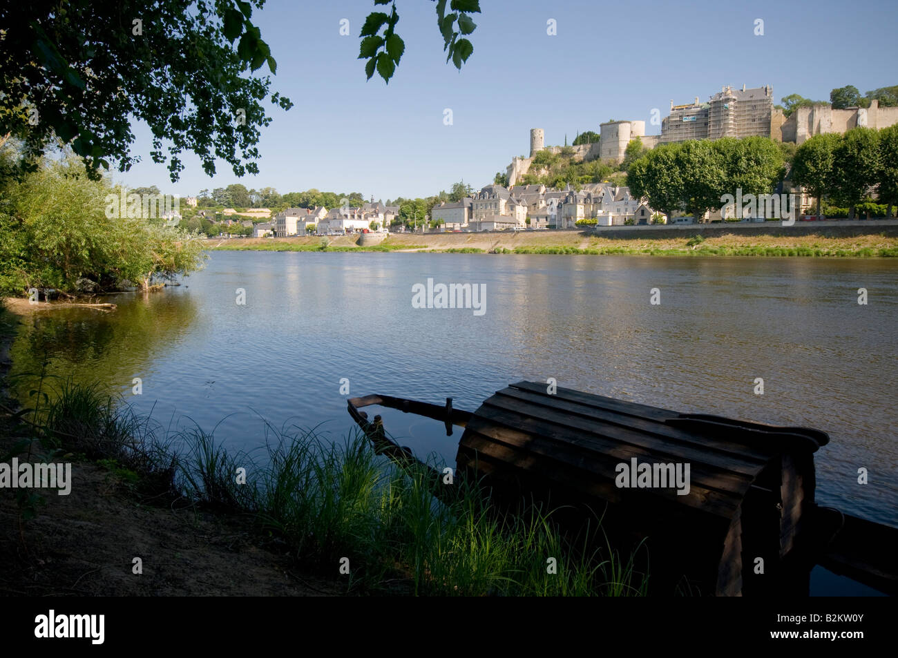Sunken boat and view across the river Vienne of the Royal Fortress of Chinon, France. Stock Photo