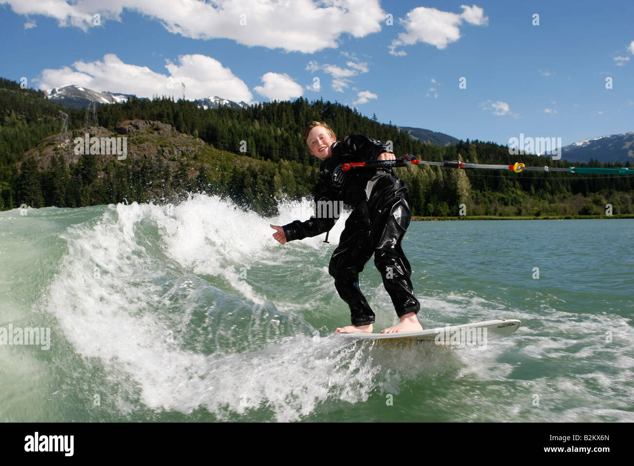 wave surfing behind a boat on green lake in whistler British Columbia