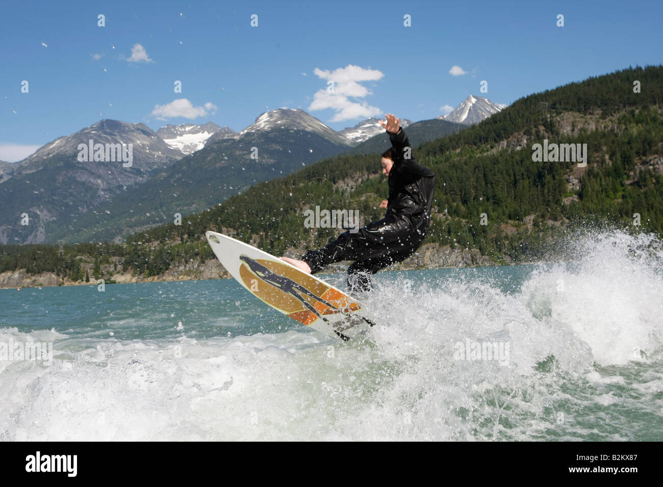 wave surfing behind a boat on green lake in whistler British Columbia