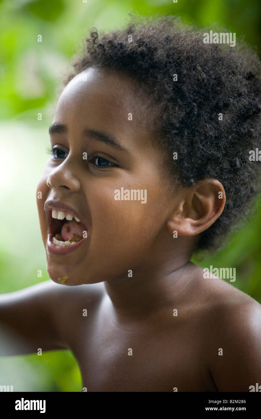 A little black boy talking with his mouth full. Petit garçon de couleur parlant la bouche pleine. Stock Photo