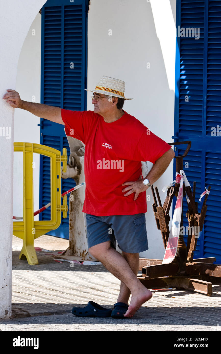 Man weared a straw hat waits in Cala Ratjada, Majorca, Spain Stock Photo
