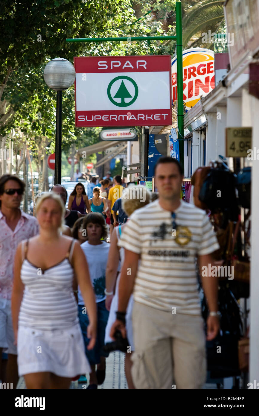 Pedestrians pass by a Spar store in Cala Ratjada, Majorca, Spain Stock Photo