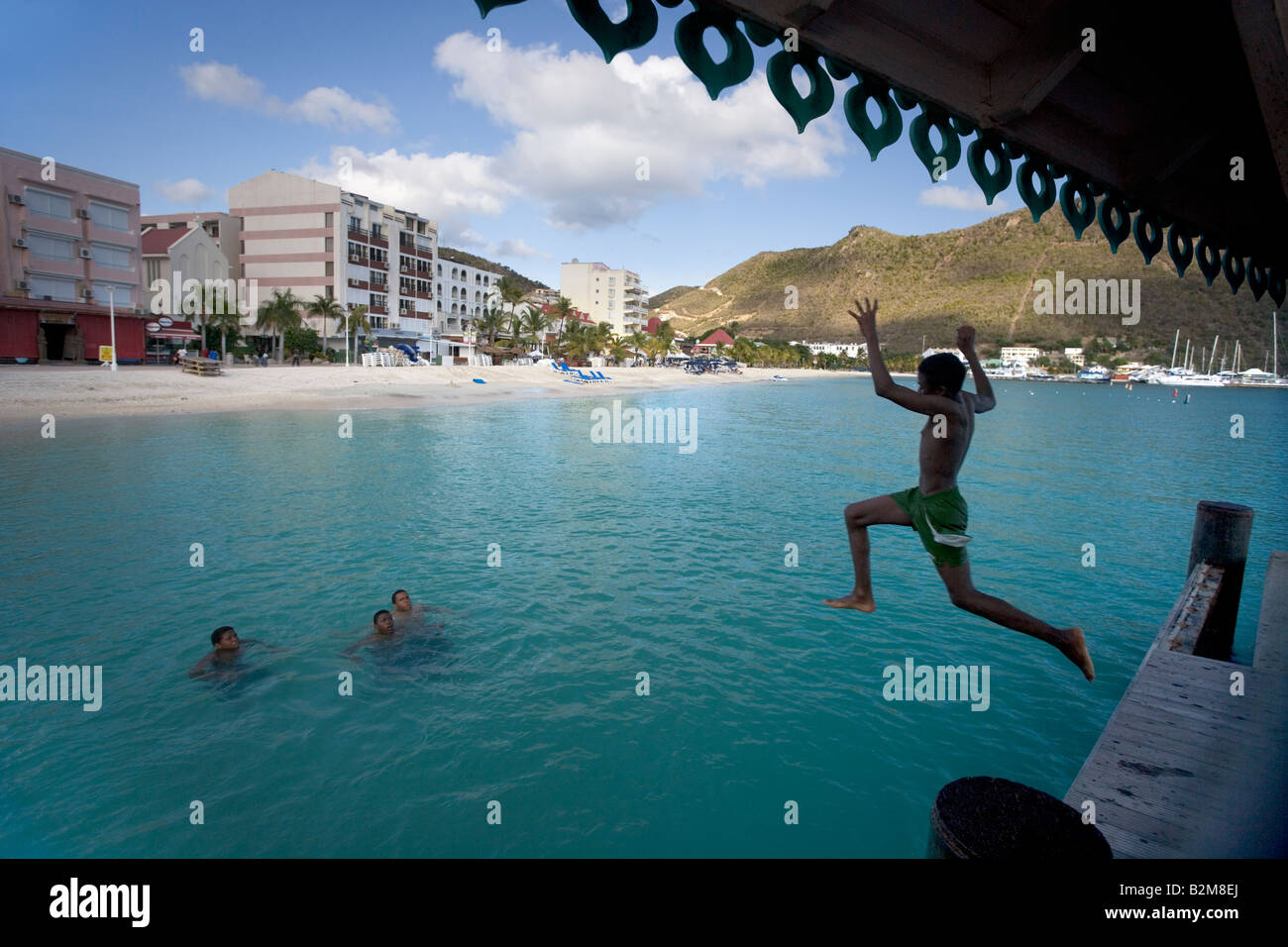 Kids jumping off a dock in Philipsburg Sint Maarten West Indies Stock Photo