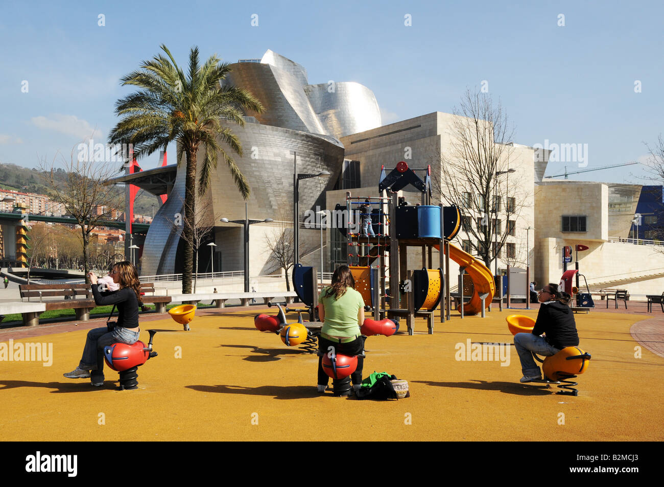 Young women girls teenagers enjoy childrens playgound in front of Museo Museum Guggenheim Bilbao Spain Stock Photo
