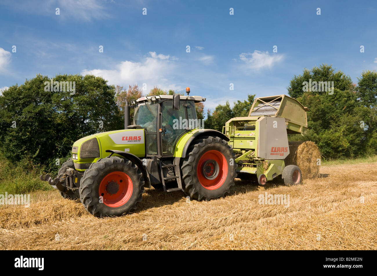 'Claas Ares 826 RZ' and 'Claas Rollant 66' straw baler at work, sud-Touraine, France. Stock Photo