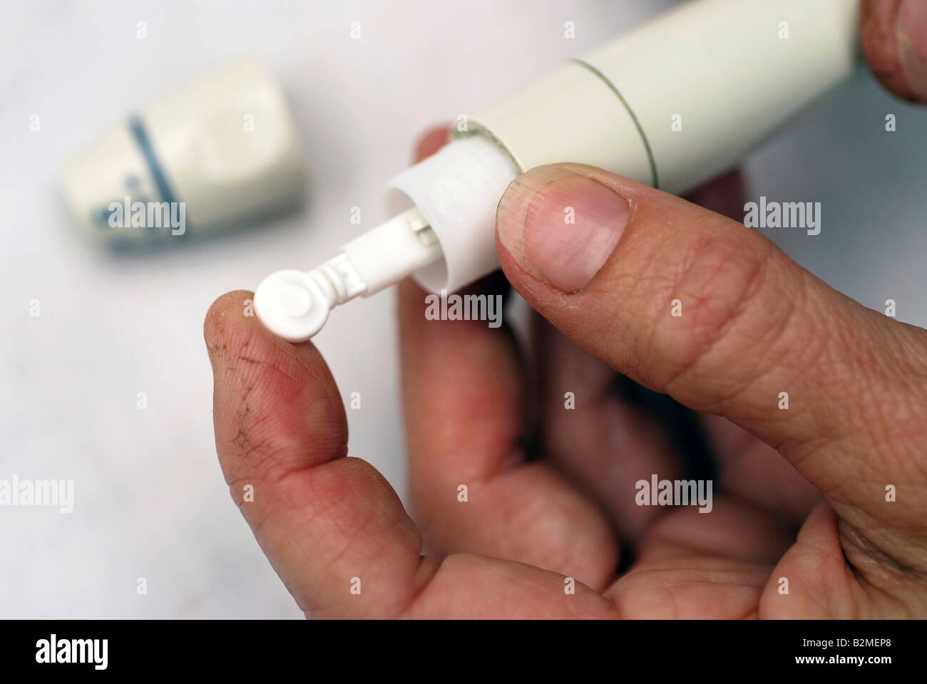 Diabetic inserting lancet in lancet applicator device Stock Photo Alamy