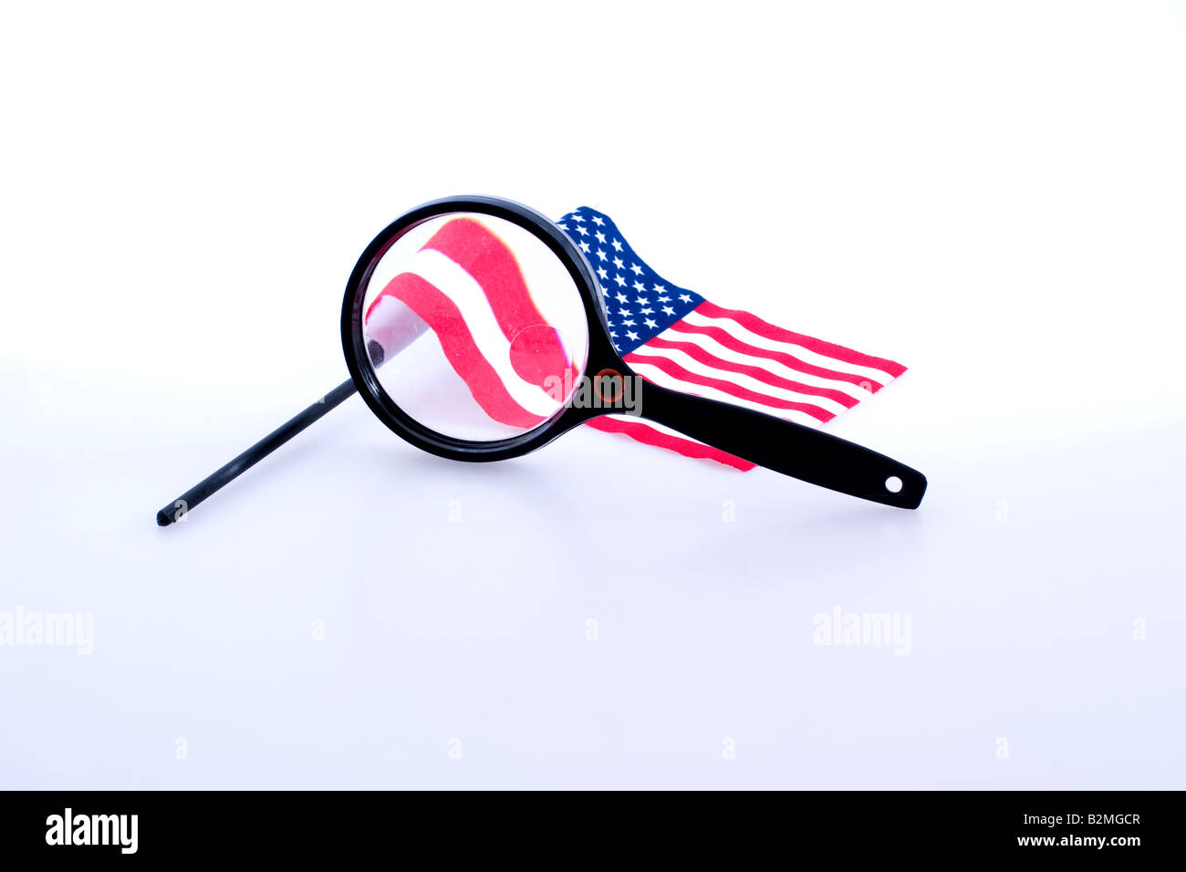 A magnifying glass in from of a United states flag Stock Photo