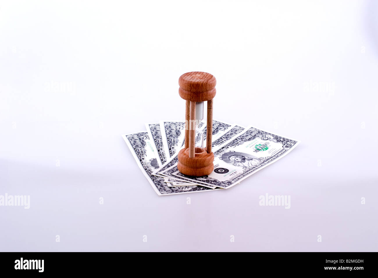 Small hourglass on top fake million dollar bills Stock Photo