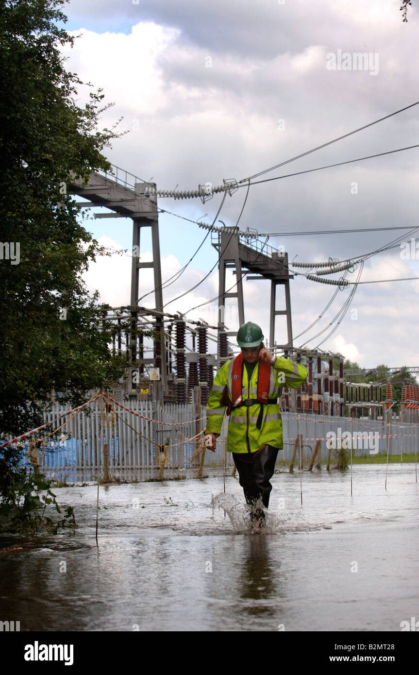 A POWER ENGINEER WADES THROUGH FLOODWATER AT THE WALHAM ELECTRICITY SUBSTATION IN GLOUCESTER WHICH WAS UNDER THREAT OF FLOODING Stock Photo