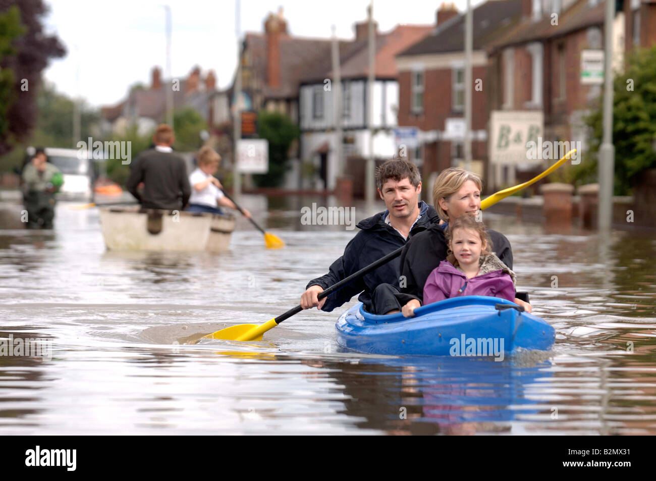 A FAMILY USE A CANOE TO NAVIGATE FLOODWATER IN TEWKESBURY ROAD SANDHURST GLOUCESTER UK JULY 2007 Stock Photo