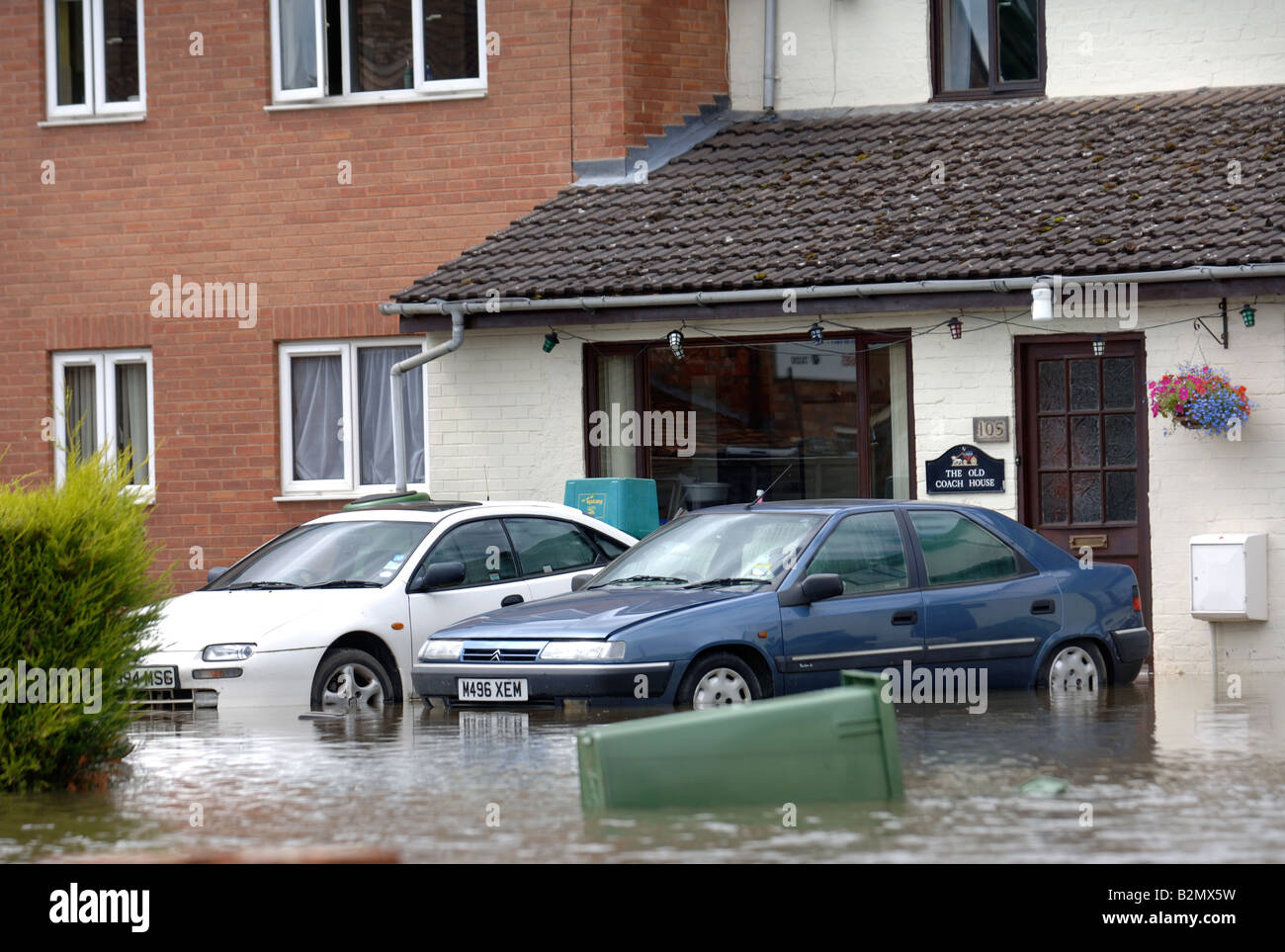 CARS ON A DRIVEWAY SWAMPED BY FLOODWATER IN TEWKESBURY ROAD SANDHURST GLOUCESTER UK JULY 2007 Stock Photo