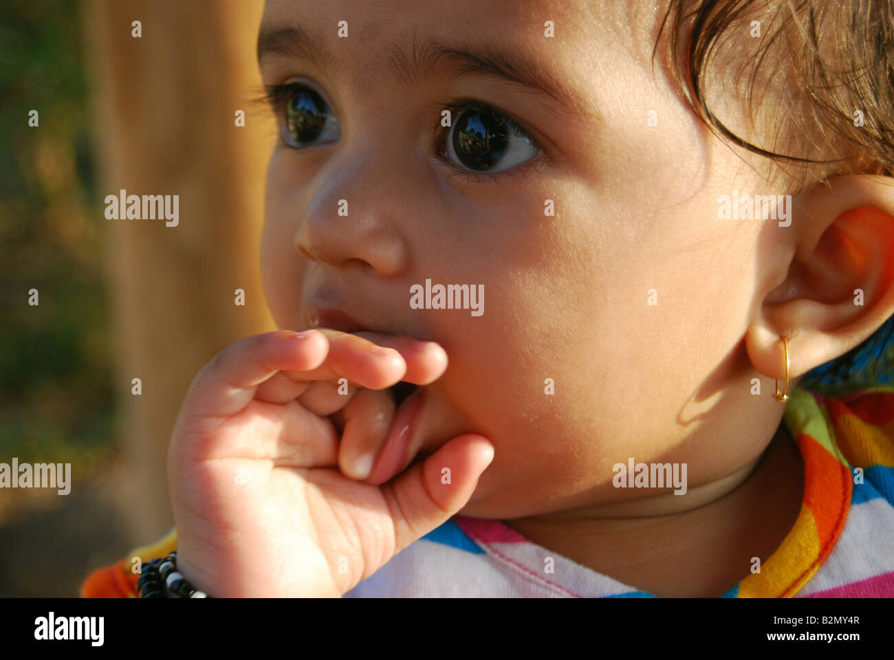 Close up of a year old baby girl sucking her fingers. Pune India Stock Photo