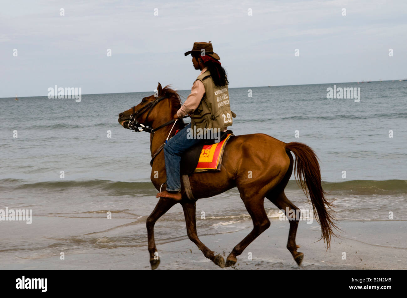 Horse riding on a tropical beach, Thailand Stock Photo